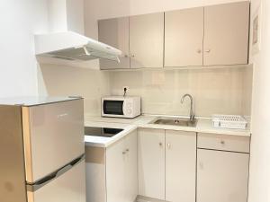 a white kitchen with a microwave and a sink at Κωνσταντίνος Έλενα Studios in Pefki +33 photos