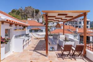 a balcony with chairs and a pergola at Manu's House - Refined Design, Effortless Space in Skopelos Town