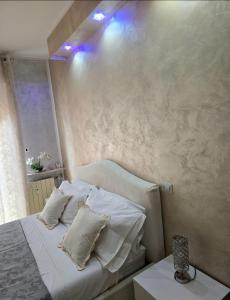 a bedroom with a bed with white sheets and pillows at Alloggio Acqui in Acqui Terme