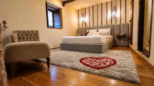 a bedroom with a bed and a couch and a heart rug at Casa Love Story - Piscina, Sauna & Jacuzzi in Arcos de Valdevez +44 photos