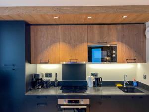 a kitchen with wooden cabinets and a counter top at L'Altima Megève in Megève