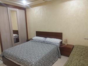 a small bedroom with a bed and a mirror at apartamente á fes in Fez +1 photo