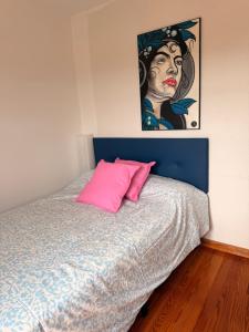 a bed with a pink pillow and a painting on the wall at Villa Terrazos in Terrazos