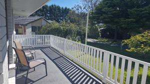 a porch with two chairs and a white fence at Spacious & Sun-Filled Highlands Retreat in Moss Vale