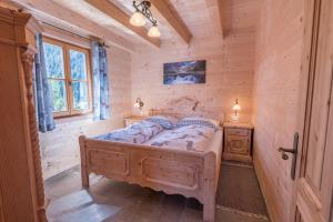 a bedroom with a bed in a log cabin at Steineralm in Schwersberg