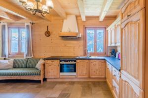 a kitchen with wooden cabinets and a couch in a room at Steineralm in Schwersberg