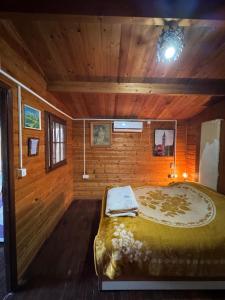 a bedroom with a large bed in a wooden room at Florea Cottage in Ulcinj
