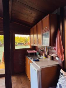 a small kitchen with wooden cabinets and a window at Florea Cottage in Ulcinj