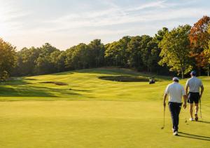two men walking on a golf course at The Cape Club Golf Resort in Falmouth