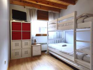 a bedroom with two bunk beds and a television at AC Apartaments Sol Tarter in El Tarter +3 photos