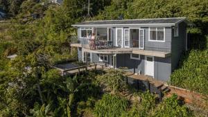 a house on the side of a hill at The Harbour Masters Cottage for Two in Tairua