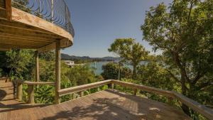 a wooden deck with a view of the water at The Harbour Masters Cottage for Two in Tairua