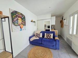 a living room with a blue couch and a rug at Studio *Sérénité* in Villejuif