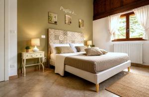 a bedroom with a bed and a table and a window at Villa Adriana - Private Pool Villa in Puglia in Andria