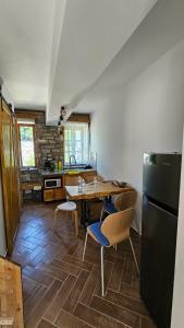 a kitchen with a table and a black refrigerator at Anderr stone Boutique in Gjirokastër