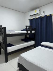 a room with three bunk beds and a blue curtain at Cabaña linamar in Coveñas