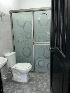 a bathroom with a toilet and a glass shower at Cabaña linamar in Coveñas +8 photos