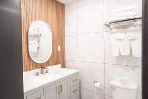 a white bathroom with a sink and a mirror at Travelodge by Wyndham Langley in Langley +22 photos