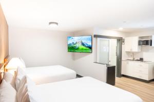 a hotel room with two beds and a tv on the wall at Travelodge by Wyndham Langley in Langley