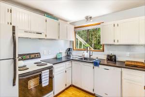 a kitchen with white cabinets and a sink at Cozy Copalis Beach Cottage Escape in Copalis Beach