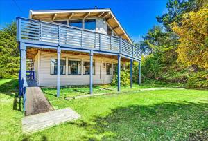 a house with a deck on top of a yard at Cozy Copalis Beach Cottage Escape in Copalis Beach