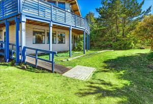 a house with a blue railing next to a yard at Cozy Copalis Beach Cottage Escape in Copalis Beach