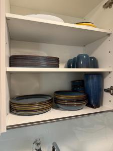 a cabinet filled with plates and bowls on shelves at Bern Garden Residence 152m Luxury Apartment in Bern