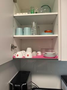 a cupboard filled with plates and bowls and dishes at Bern Garden Residence 152m Luxury Apartment in Bern