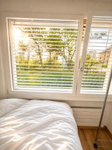 a bedroom with a bed and a large window at Bern Garden Residence 152m Luxury Apartment in Bern