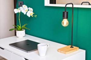 a desk with a laptop and a green wall at APPARTAMENTI LEONE - Vista Mare - Pet Friendly in Rimini +13 photos