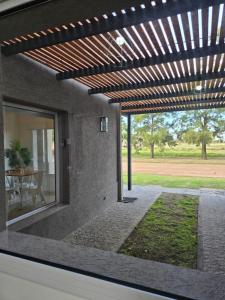 an external view of a patio with a wooden pergola at Casita Cómoda y Acogedora in Trenque Lauquen