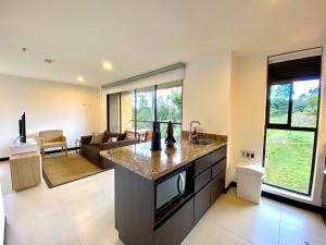 an open kitchen and living room with a couch at Hotel Rioverde Living Suites in San Antonio de Pereira
