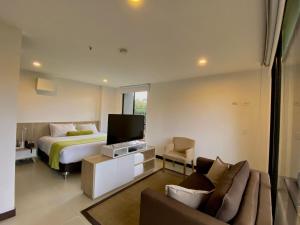 a bedroom with a bed and a tv and a couch at Hotel Rioverde Living Suites in San Antonio de Pereira