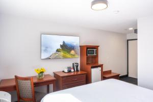 a room with a bed and a desk and a microwave at Travelodge by Wyndham Langley in Langley