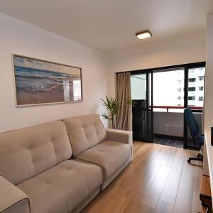 a living room with a couch and a desk at Metropolitan Flats in Curitiba
