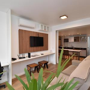 a living room with a couch and a flat screen tv at Metropolitan Flats in Curitiba