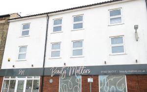 a white building with a sign in front of it at Easterly Sleeps in Lowestoft