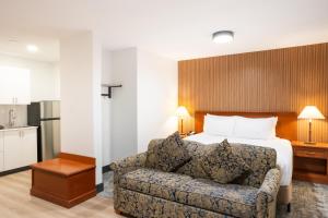a hotel room with a bed and a couch at Travelodge by Wyndham Langley in Langley