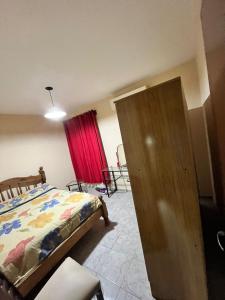 a bedroom with a bed and a red curtain at Casa Bella Vista in Pocito