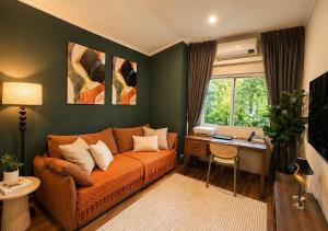 a living room with a couch and a desk at SvoyLuX Primo 3BR Gated House Near Pier and Muay Thai Street in Phuket