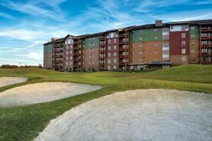 a golf course with a large apartment building in the background at Club Wyndham Great Smokies Lodge in Sevierville