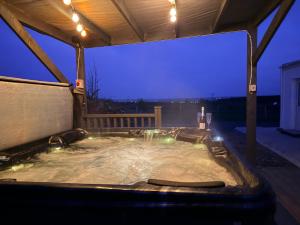a jacuzzi tub in a backyard at night at The Cottage in Ballaghaderreen