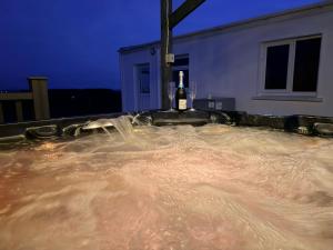 a hot tub with a bottle of wine in it at The Cottage in Ballaghaderreen