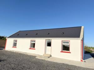 a white house with a black roof at The Cottage in Ballaghaderreen