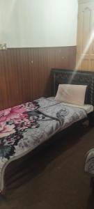 a bed with a blanket and a pillow on it at Hamala Inn Hotel in Abbottabad