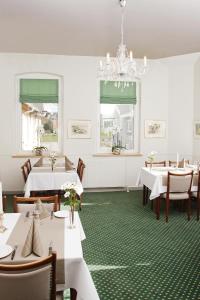 a dining room with tables and chairs and a chandelier at Sølyst Kro- Restaurant og Hotel I/S in Aabenraa