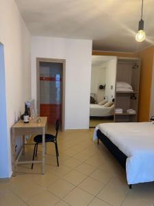a bedroom with a bed and a desk and a bed at Holidays House Il Vicoletto in Sulmona