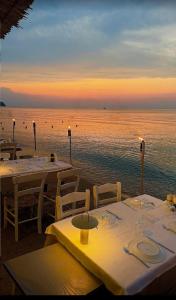 a group of tables on the beach with the ocean at Sole Di Mare Agia Triada in Agia Triada