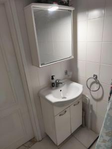 a white bathroom with a sink and a mirror at Sole Di Mare Agia Triada in Agia Triada