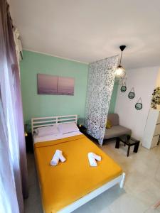 a bedroom with a yellow bed with towels on it at Sole Di Mare Agia Triada in Agia Triada